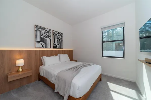 a bedroom with a bed and a flat screen tv