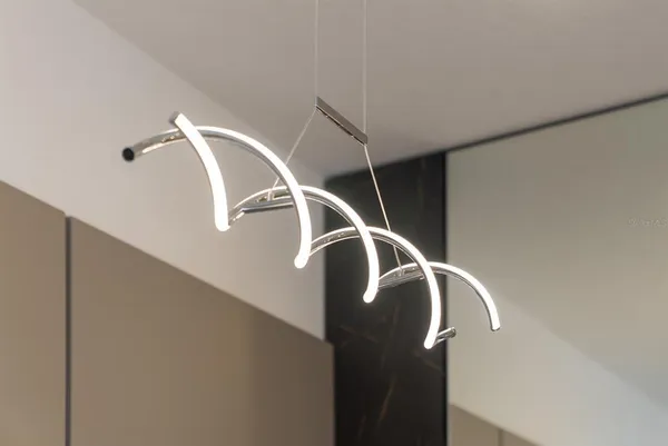 a kitchen with a stove a sink a kitchen island with chairs and cabinets