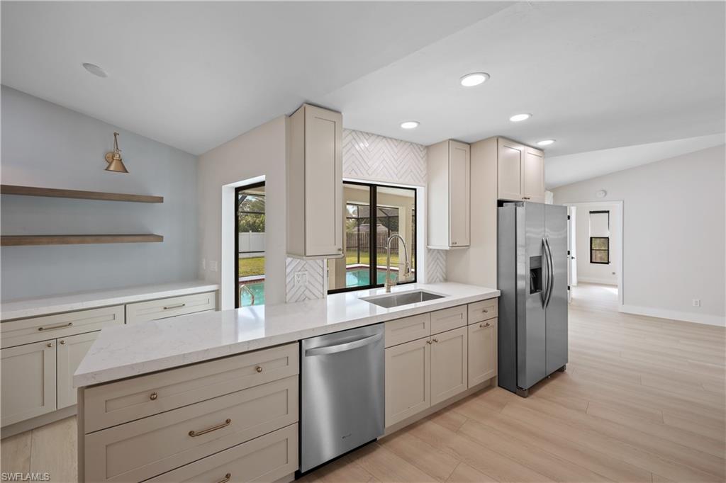 121 Fairway Circle Naples, FL 34110 - Photo 3 of 31 a large white kitchen with stainless steel appliances granite countertop a refrigerator and a sink