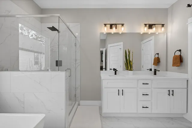 a bathroom with a bathtub shower sink vanity and toilet