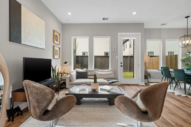 a living room with furniture a flat screen tv and a table