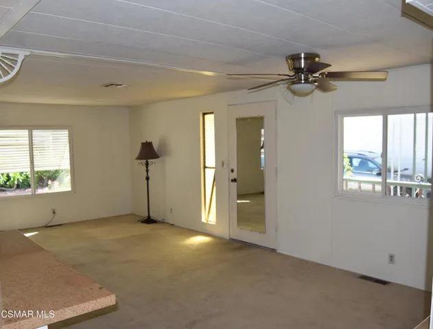an empty room with windows and fan
