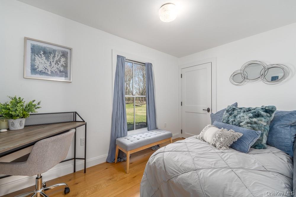19000 Main Road Mattituck, NY 11952 - Photo 13 of 32 a bedroom with a bed and a potted plant