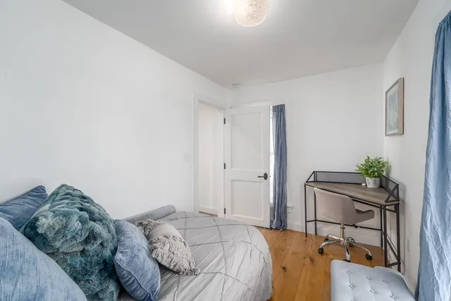 a bed sitting in a bedroom next to a window