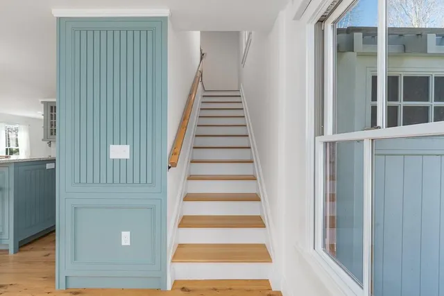 a view of a hallway with wooden floor and windows