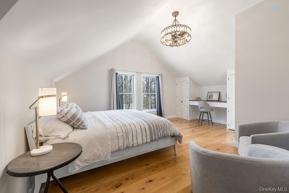 19000 Main Road Mattituck, NY 11952 - Photo 18 of 32 a bedroom with a large bed and a chandelier