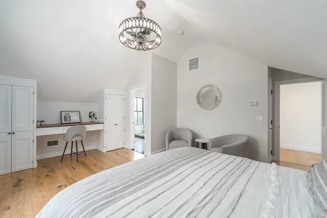 a bedroom with a bed and a chandelier