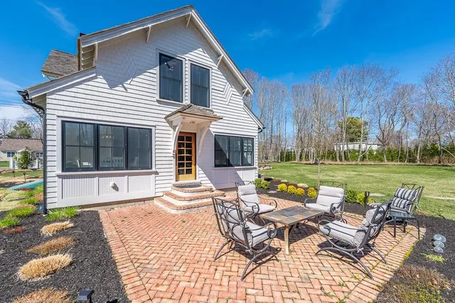 a view of a house with backyard and sitting area