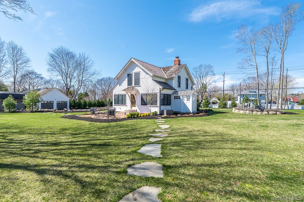 19000 Main Road Mattituck, NY 11952 - Photo 30 of 32 a front view of a house with a fountain table and chairs