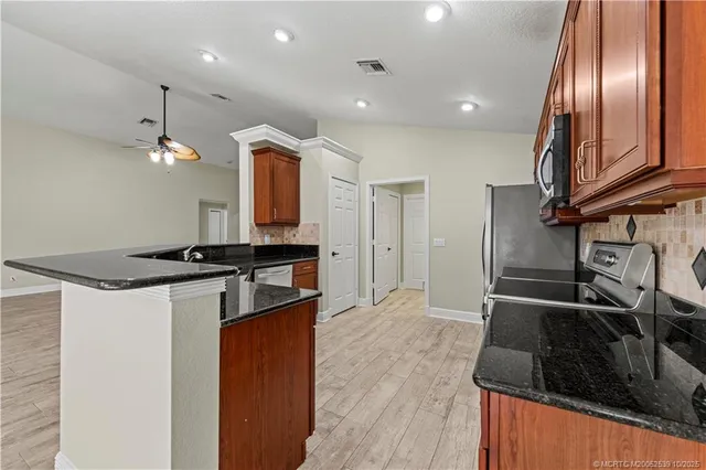 a kitchen with granite countertop stainless steel appliances and wooden floor