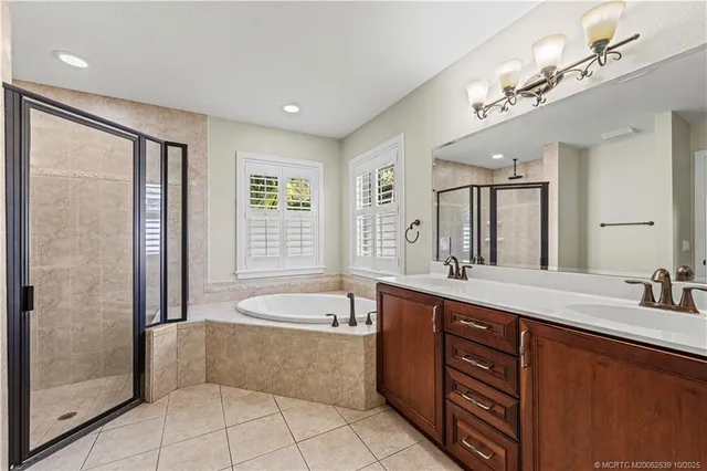 a spacious bathroom with a tub sink shower and mirror