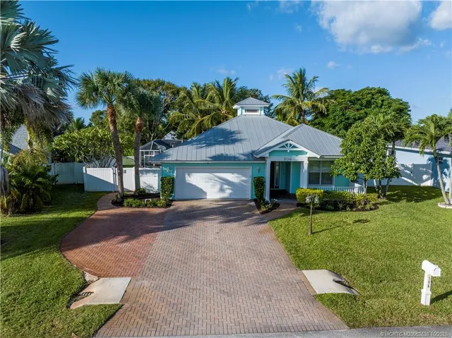 a front view of a house with a yard and trees