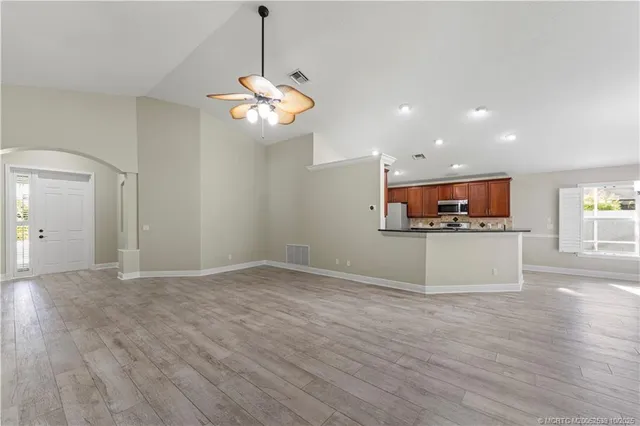 a view of a kitchen with a stove wooden cabinet a kitchen island and stainless steel appliances