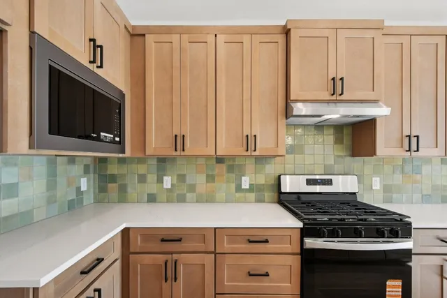 a kitchen with stainless steel appliances granite countertop a sink a stove and a wooden floors