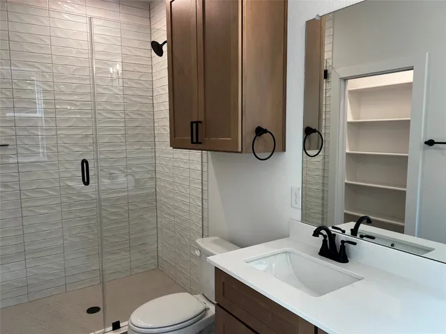 a bathroom with a sink a toilet and shower