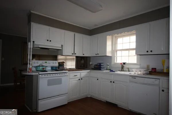 a kitchen with a sink stove top oven and cabinets