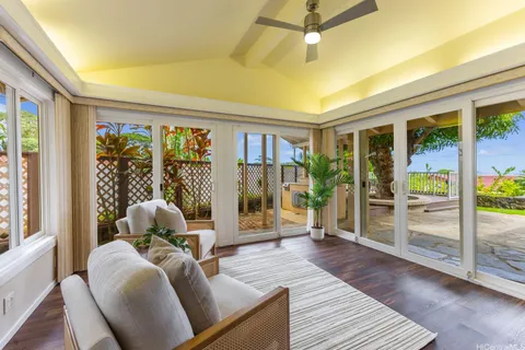 a living room with furniture floor to ceiling window and wooden floor