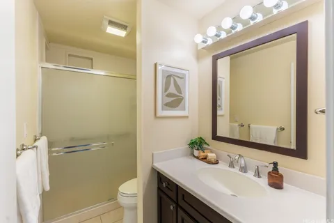 a bathroom with a sink a toilet a mirror and shower