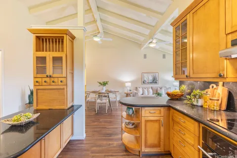 a kitchen with granite countertop a sink stove and cabinets