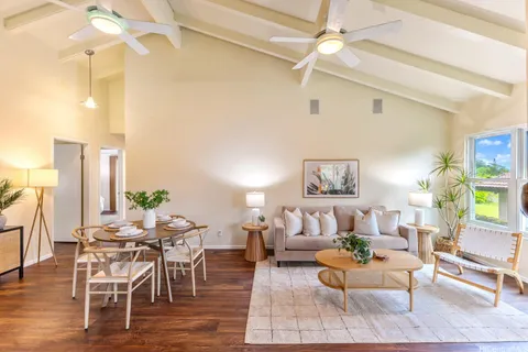 a living room with furniture and a painting on the wall