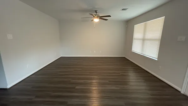 wooden floor in an empty room with a window