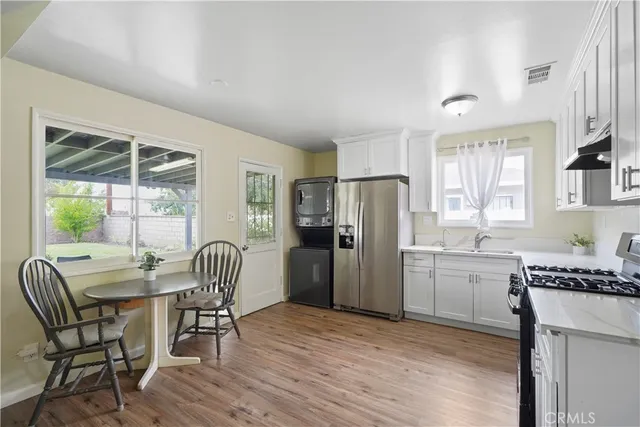 a kitchen with refrigerator a table and chairs