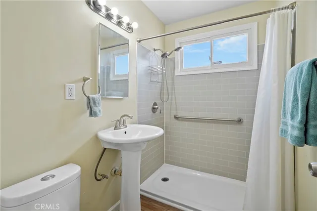 a bathroom with a sink a toilet and shower