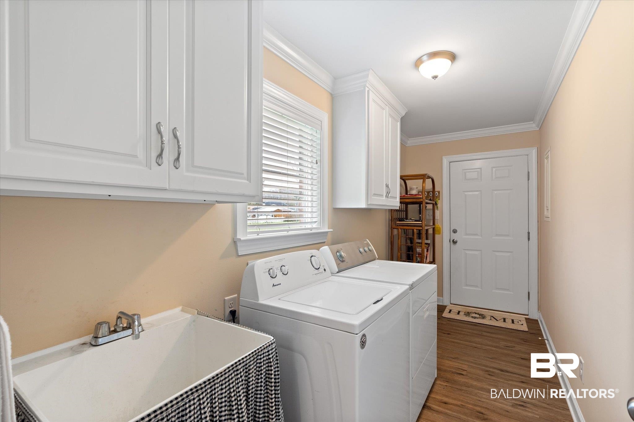 734 West Section Avenue Foley, AL 36535 - Photo 25 of 50 Washroom featuring crown molding, washer and clothes dryer, wood finished floors, cabinet space, and a sink