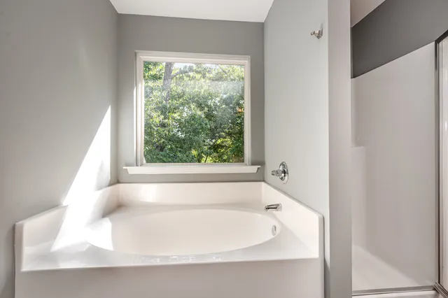 a bathroom with bathtub and window