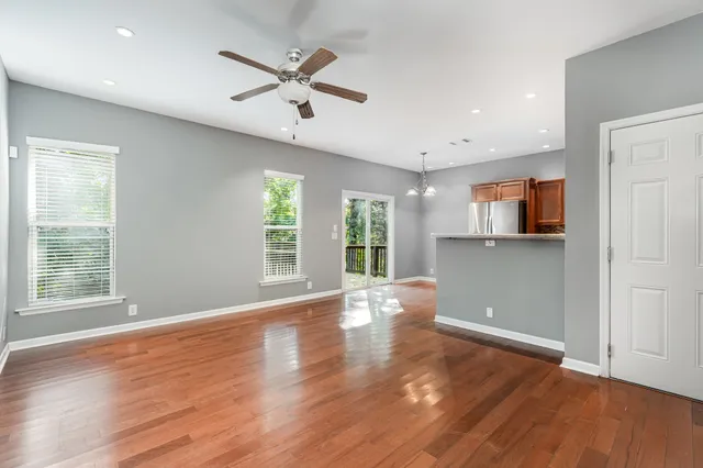 a view of an empty room with window and wooden floor