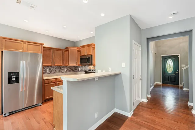 a kitchen with stainless steel appliances granite countertop a refrigerator and a sink