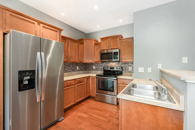 a kitchen with stainless steel appliances granite countertop a refrigerator stove microwave and sink