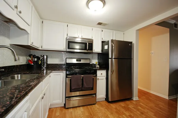 a kitchen with stainless steel appliances granite countertop a refrigerator stove and sink