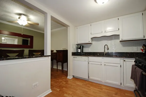 a kitchen with granite countertop a sink cabinets and stainless steel appliances