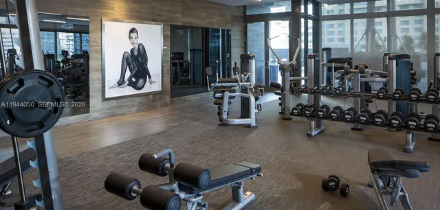a room with gym equipment and large windows