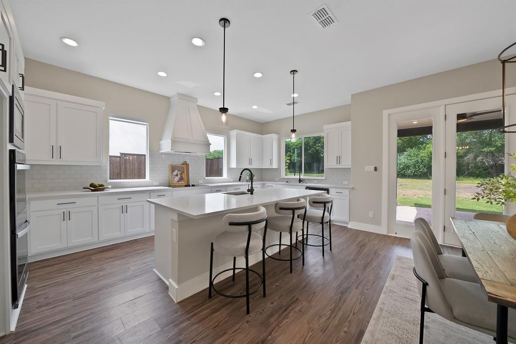 2223 Providence Way Nevada, TX 75173 - Photo 23 of 40 a kitchen with a table chairs stove and wooden floor