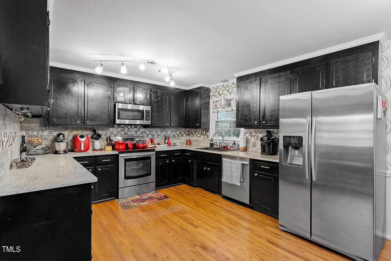 1660 Benson Road Angier, NC 27501 - Photo 11 of 32 a kitchen with kitchen island a sink stainless steel appliances and cabinets