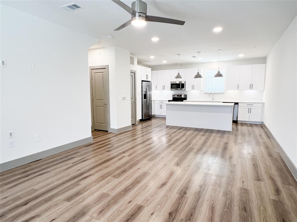 4020 McEwen Road, Unit 4106 Farmers Branch, TX 75244 - Photo 26 of 26 Kitchen with open floor plan, pendant lighting, a center island, white cabinets, and light countertops