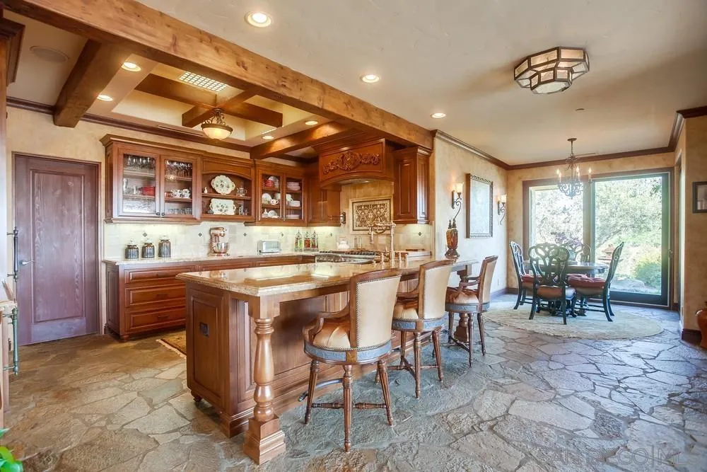 5653 Linea Del Cielo Rancho Santa Fe, CA 92067 - Photo 13 of 46 a dining hall with stainless steel appliances kitchen island granite countertop furniture and a large window