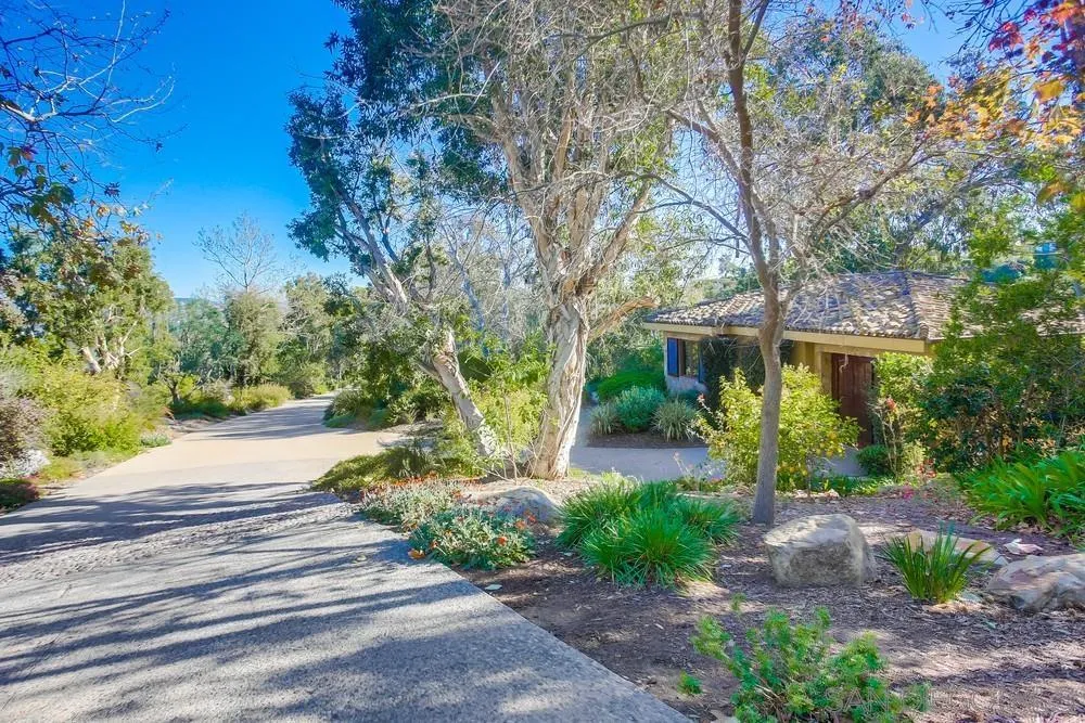 5653 Linea Del Cielo Rancho Santa Fe, CA 92067 - Photo 39 of 46 a front view of a house with a yard and a garden
