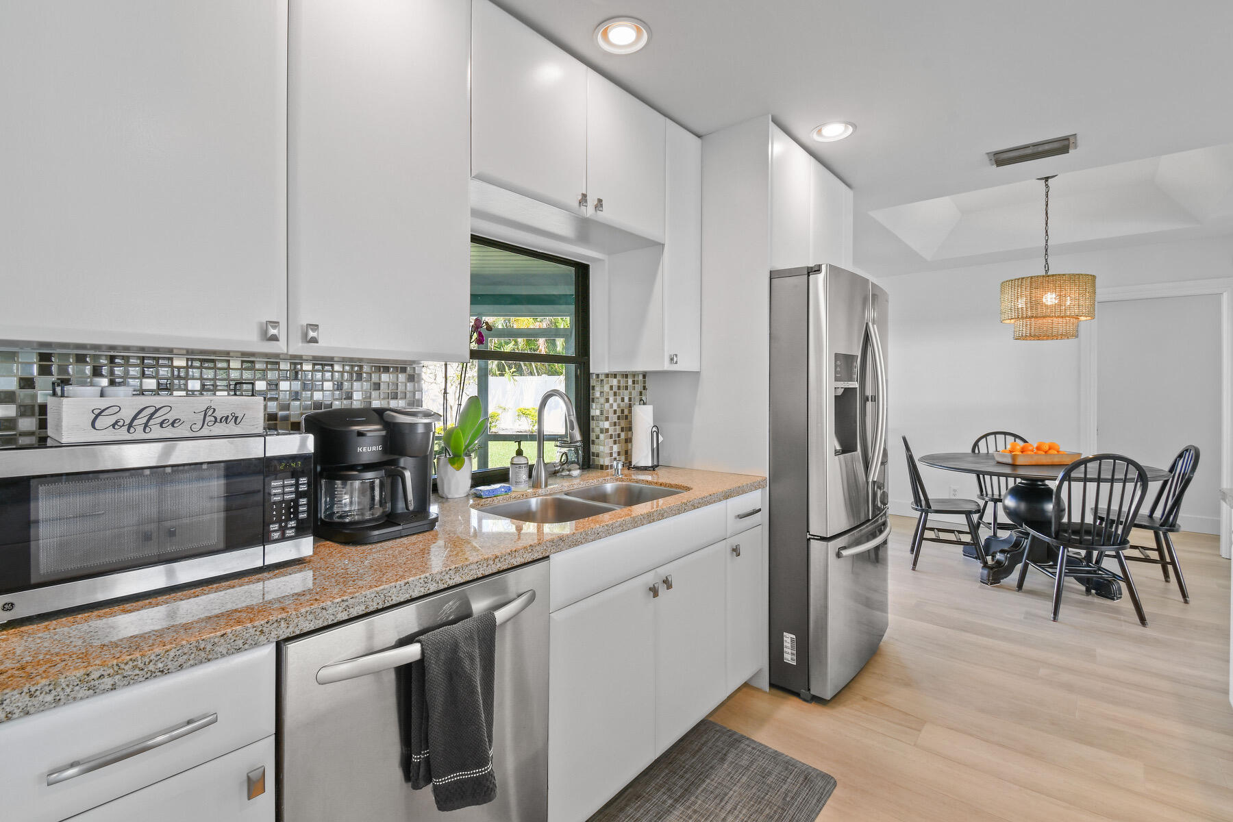 4153 Wingo Street Jupiter, FL 33469 - Photo 13 of 39 a kitchen with stainless steel appliances a refrigerator a stove a sink and chairs