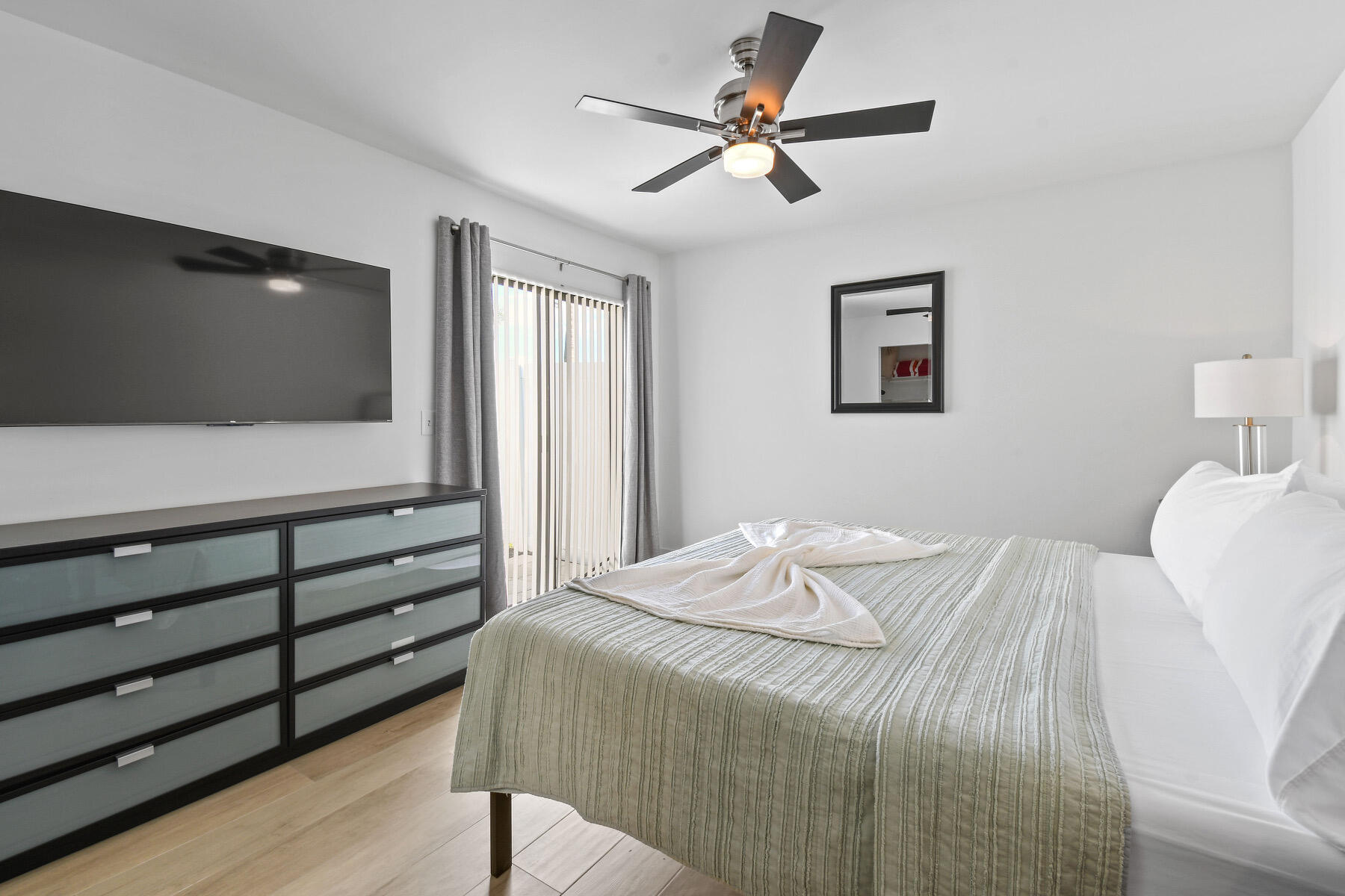 4153 Wingo Street Jupiter, FL 33469 - Photo 17 of 39 a bedroom with a bed and a flat screen tv