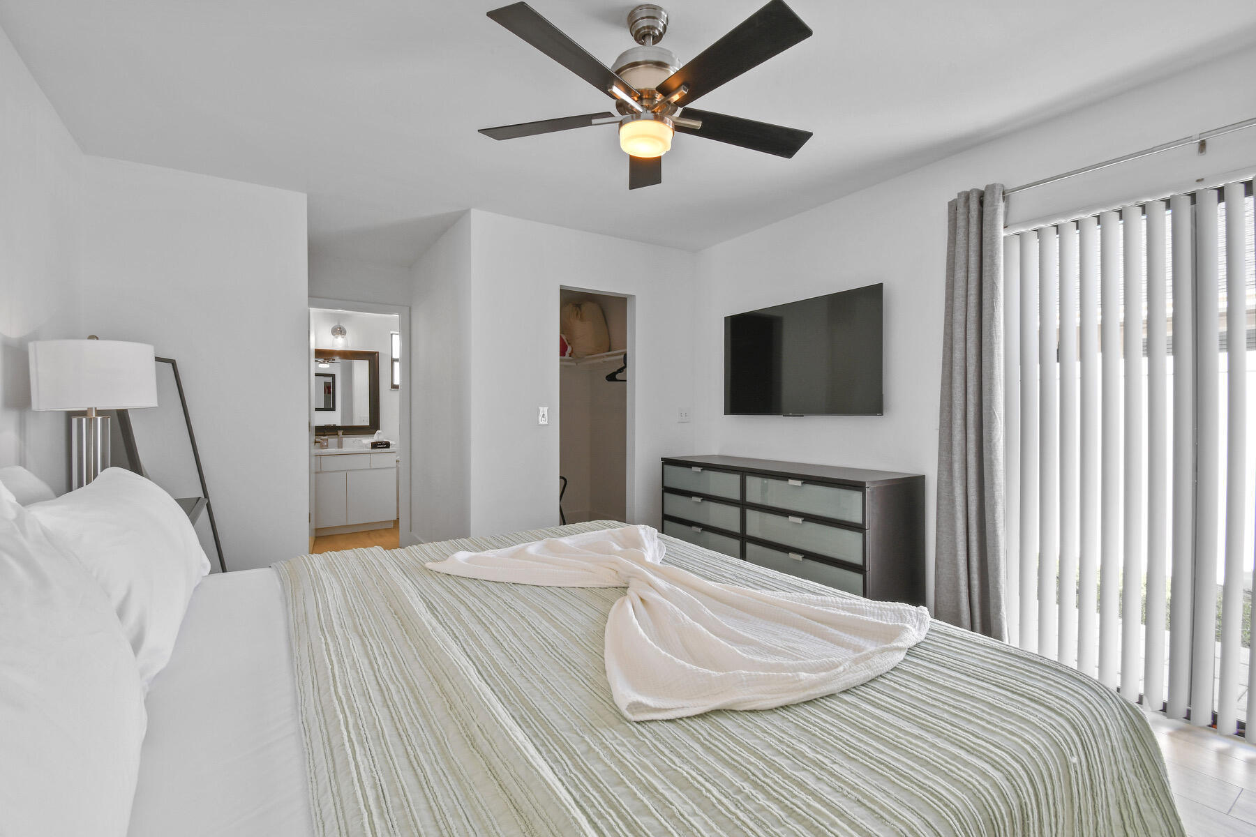 4153 Wingo Street Jupiter, FL 33469 - Photo 19 of 39 a bedroom with a bed and a flat screen tv