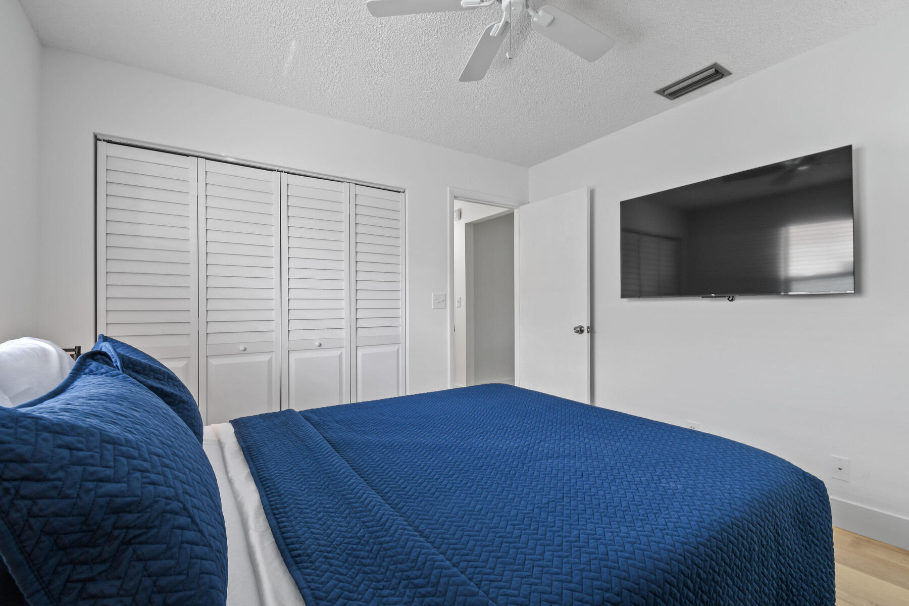4153 Wingo Street Jupiter, FL 33469 - Photo 23 of 39 a bedroom with a bed and a flat screen tv