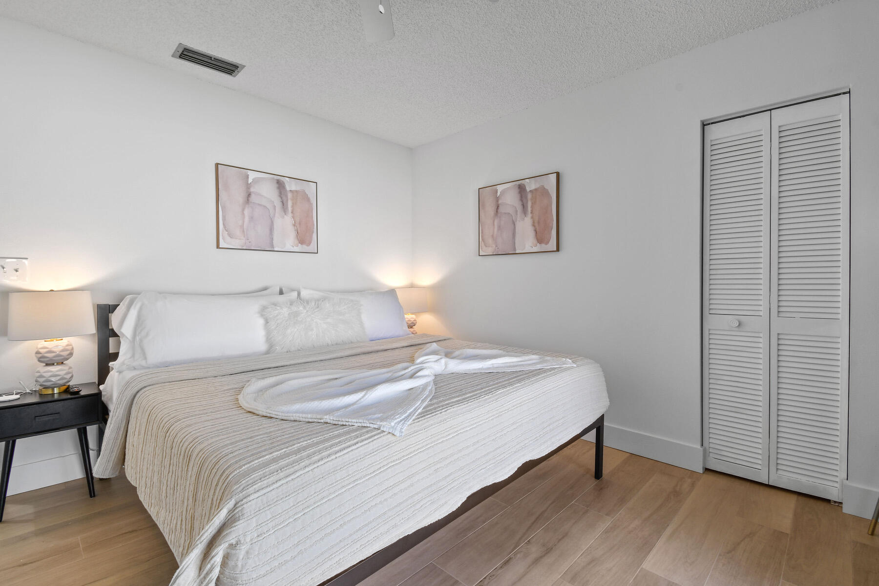 4153 Wingo Street Jupiter, FL 33469 - Photo 30 of 39 a bedroom with a bed and wooden floor