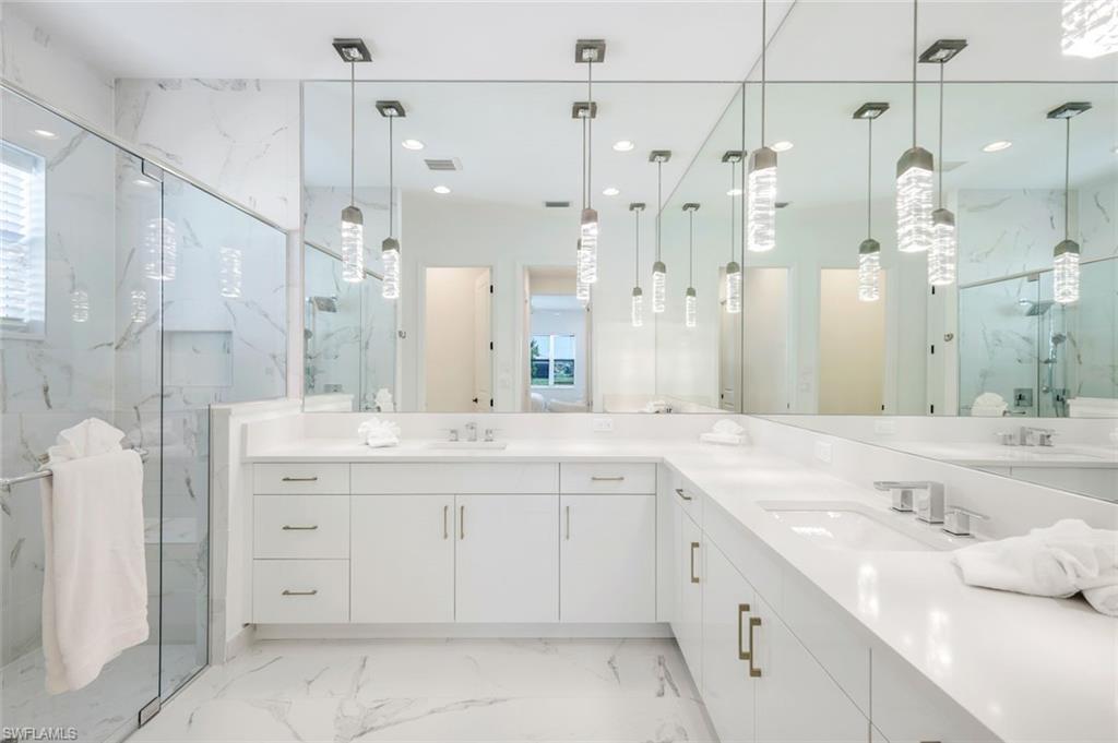 11322 Jacaranda Drive Naples, FL 34120 - Photo 18 of 42 a spacious bathroom with a granite countertop sink mirror and a shower
