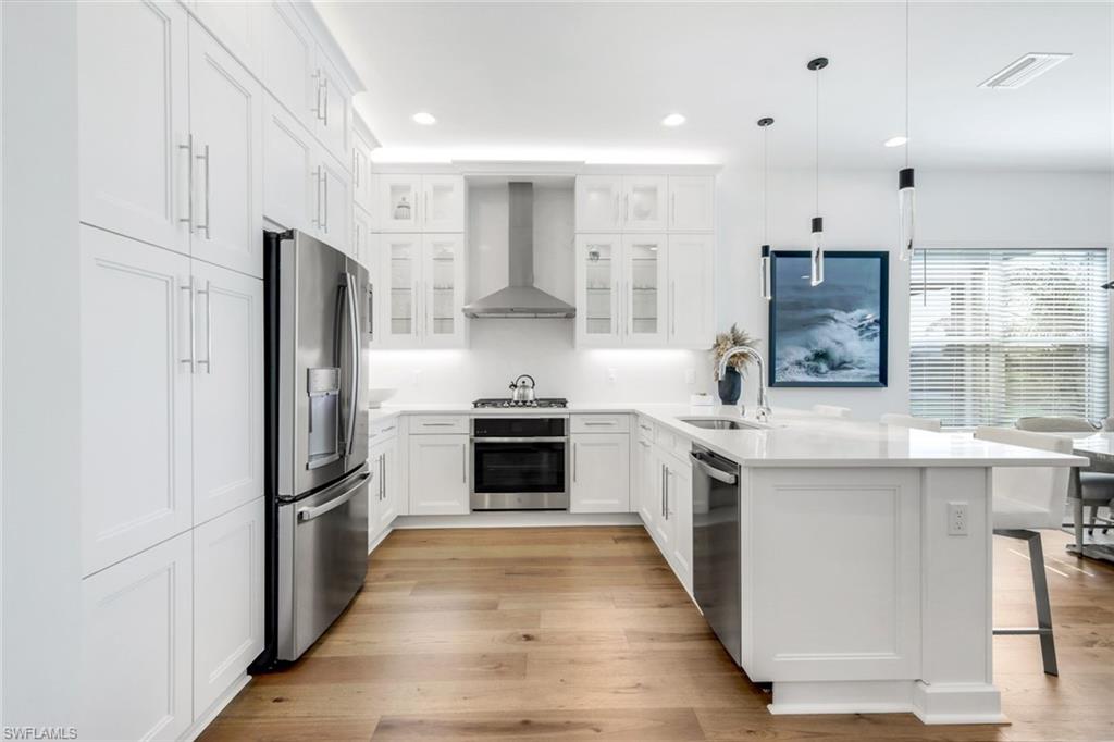 11322 Jacaranda Drive Naples, FL 34120 - Photo 22 of 42 a kitchen with stainless steel appliances granite countertop a refrigerator a stove and a sink