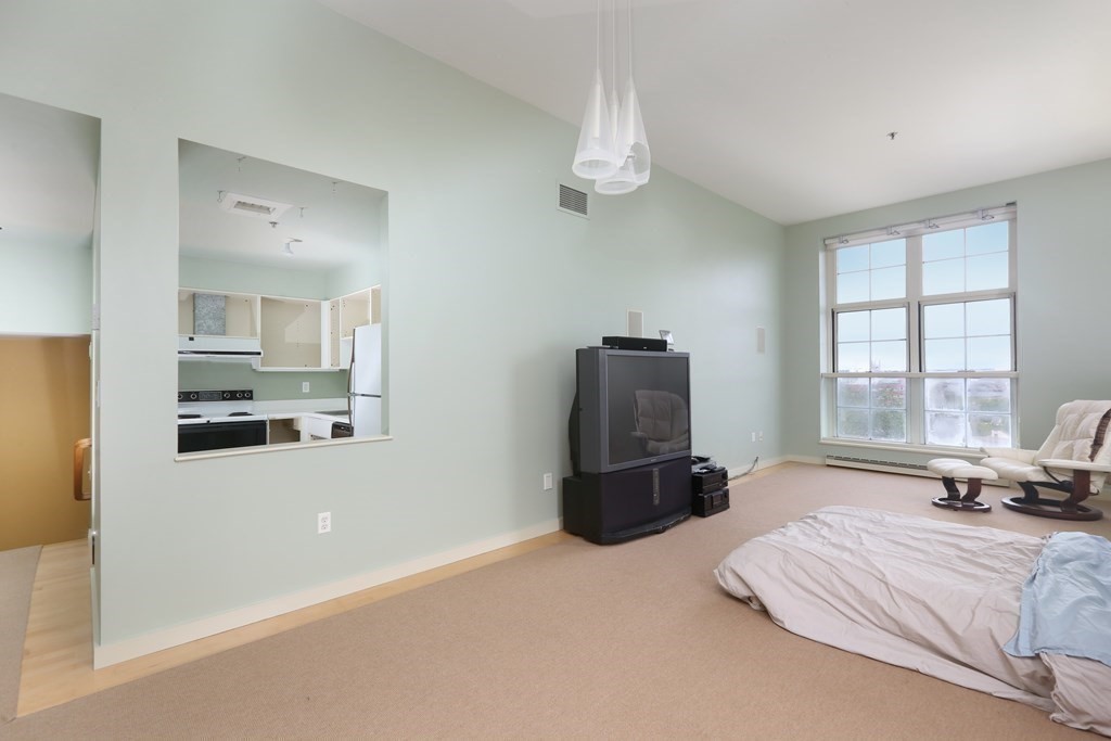 30 Monument Square, Unit 404 Boston, MA 02129 - Photo 6 of 14 a bedroom with a bed dresser and a large window