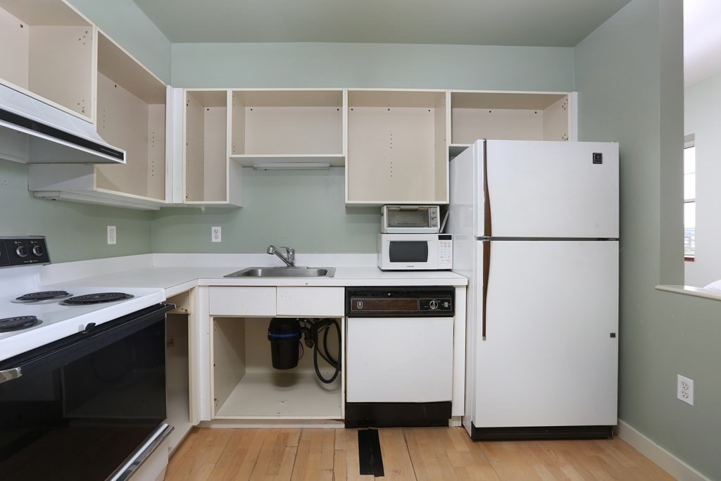 30 Monument Square, Unit 404 Boston, MA 02129 - Photo 7 of 14 a kitchen with a sink a refrigerator and a stove