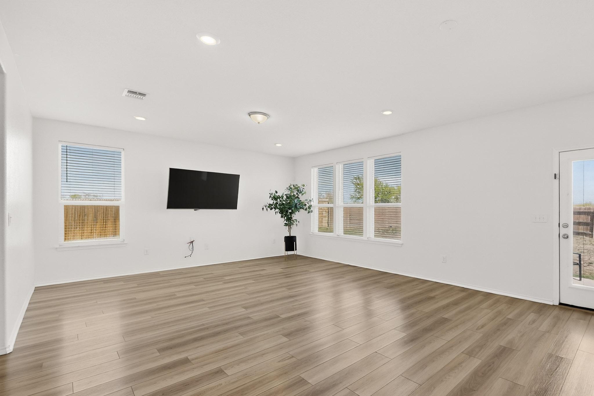 14513 Booted Eagle Pass Elgin, TX 78621 - Photo 12 of 33 Spacious living area with abundant natural light, open sightlines, and flexible